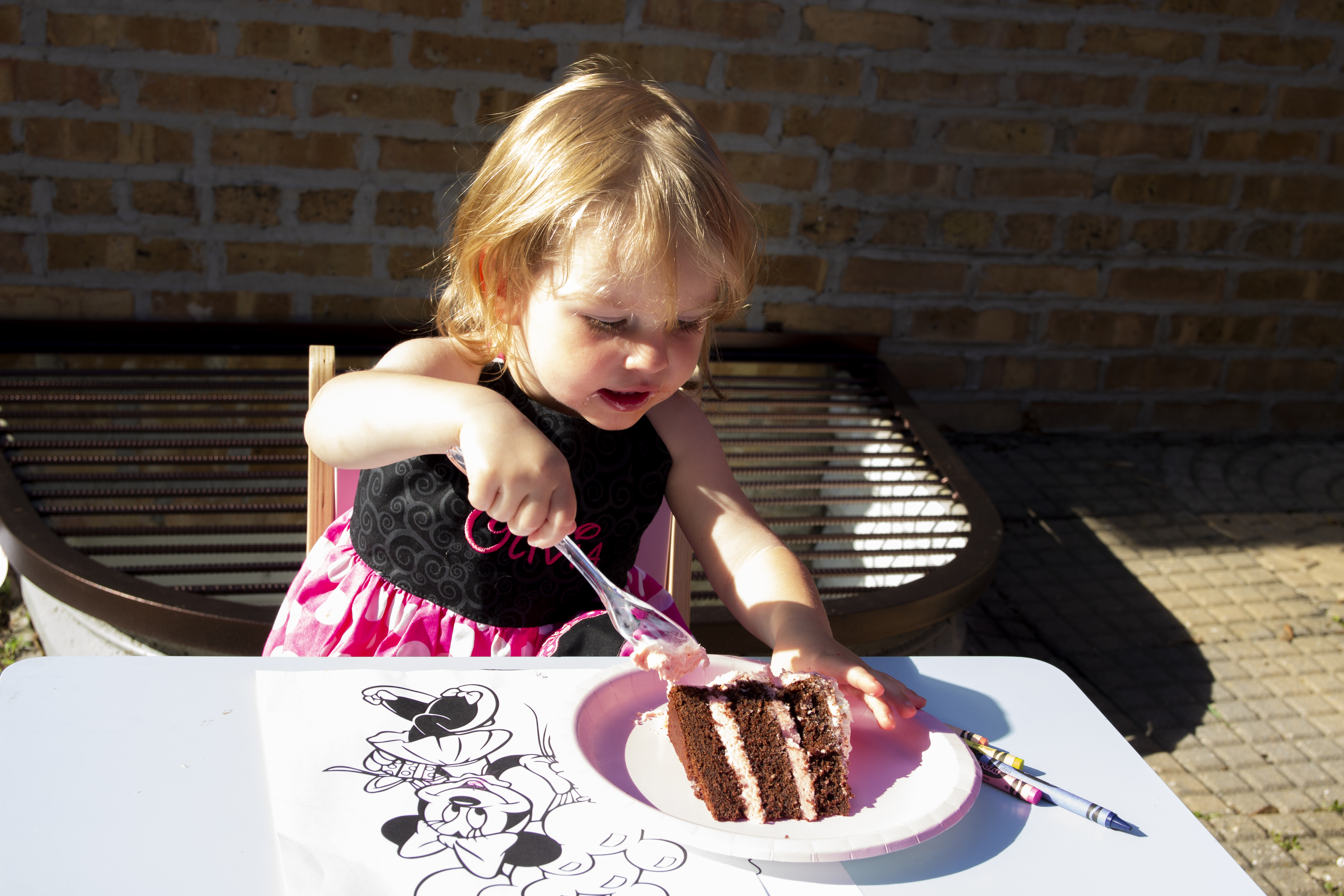 Two year old eating her birthdy cake at her minnie mouse birthday party