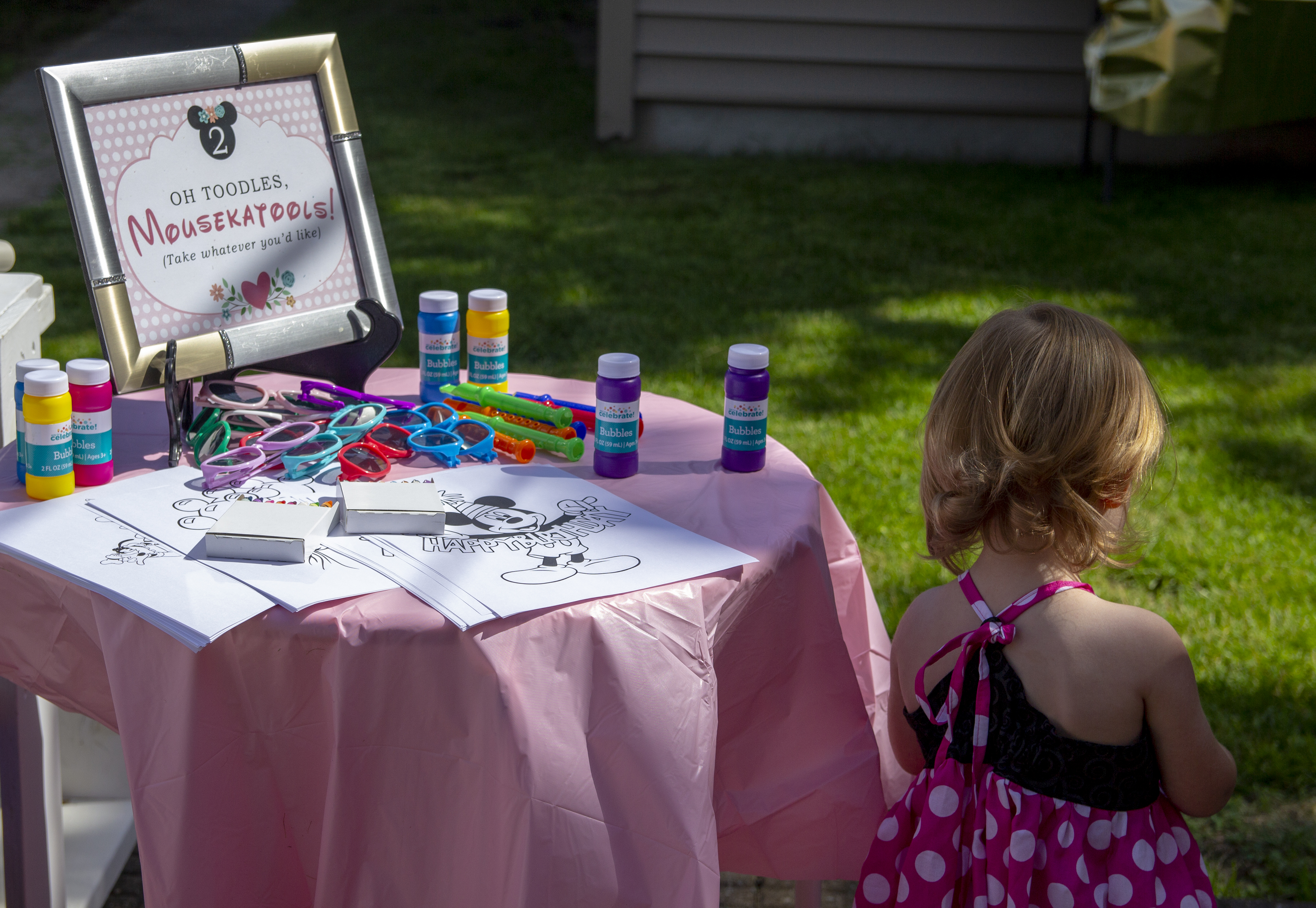 Table with games and party favors for 2 year old minnie mouse birthday party