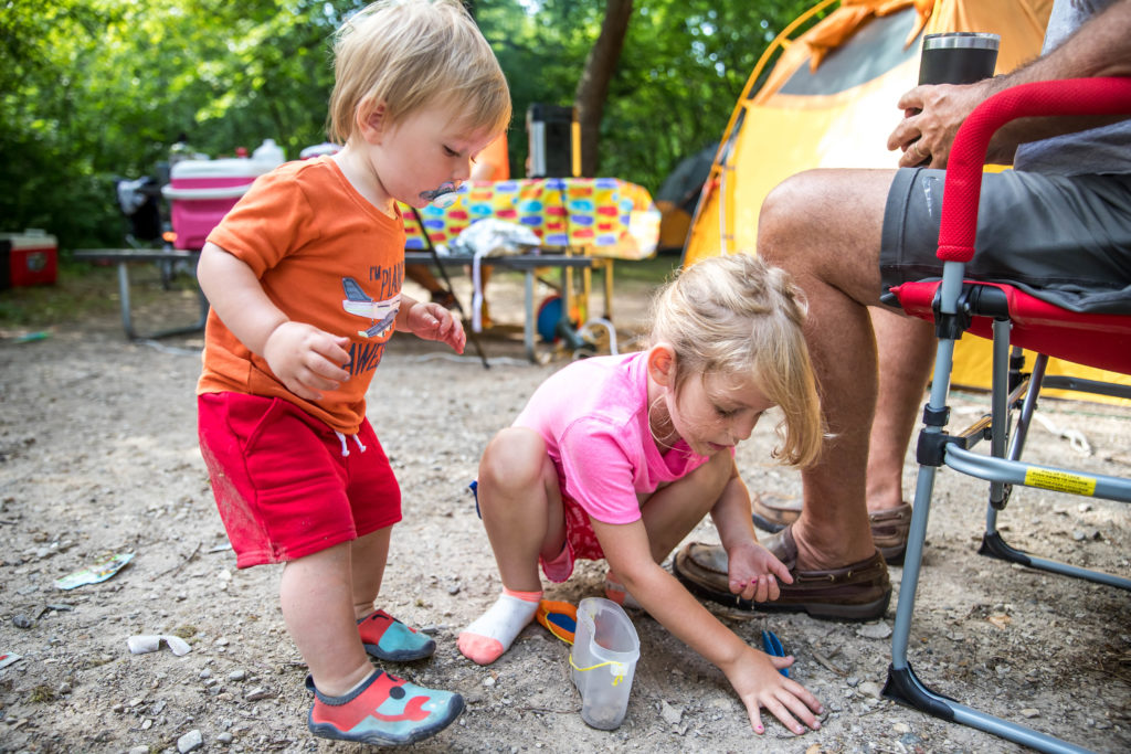 4-year old teaches 1-year old about bug hunting while on a camping trip