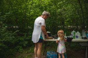 4-year old helping grandma cook breakfast during a camping trip