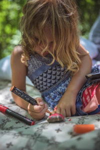 4-year old painting rocks during a camping trip