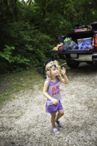 4 year old wear headlamp around campsite while tent camping
