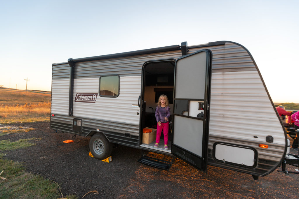 4 year old standing inside travel trailer while staying at an Alpaca farm with Harvest Hosts