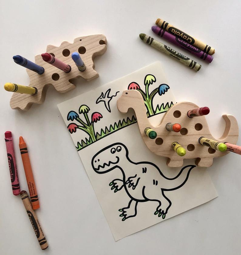 Dinosaur crayon holder being used to stop crayons from rolling away