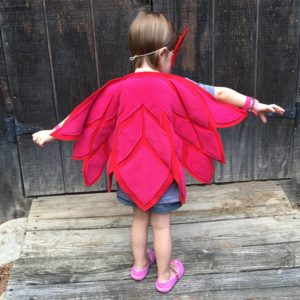 Toddler girl dressing up with owl wings