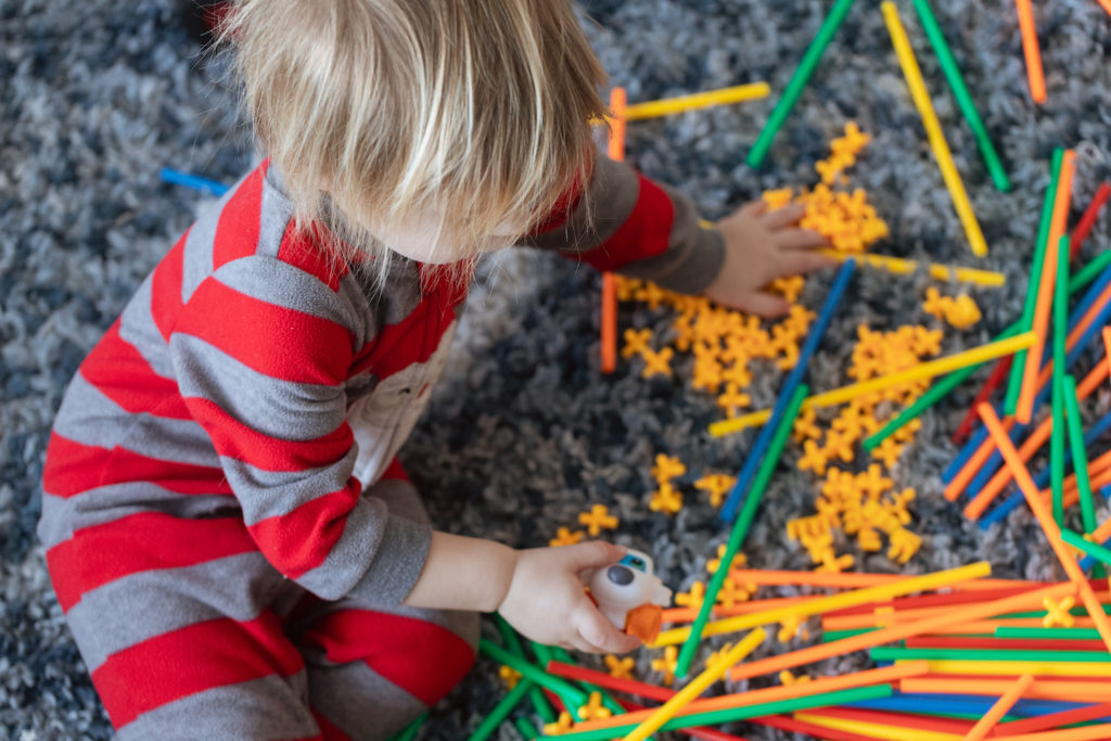 One-year-old playing with a straw building set