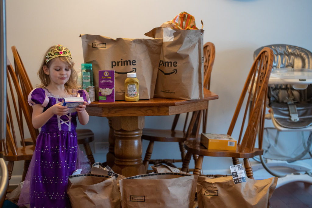 4-year-old looking at groceries from Amazon Fresh delivery